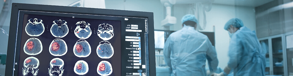 A screen showing the results of a scan, with surgeons in the background