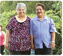 A couple smile outdoors