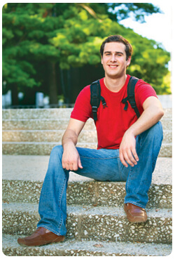 A man sits on steps in a park